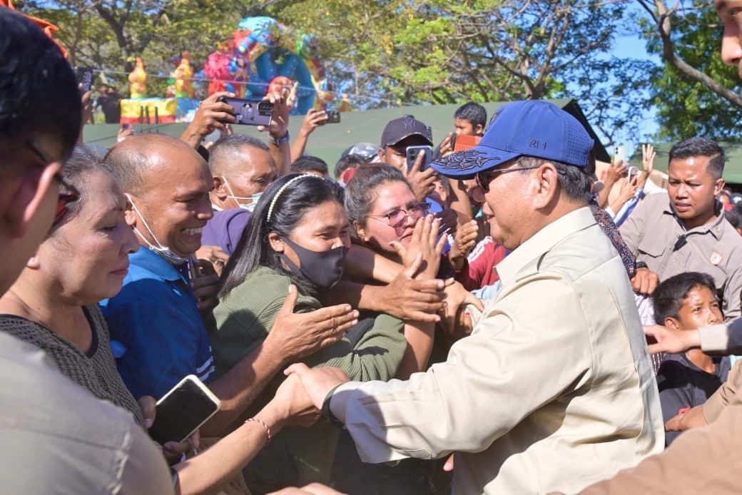 Tak ada jarak yang terasa. Sejumlah warga mendekat, menjabat tangan, bahkan memeluk Presiden. Di tengah kerumunan itu, seorang anak perempuan tampak tersenyum lebar sambil berdiri begitu dekat dengan Presiden. Anak-anak lainnya ikut mengerubungi Kepala Negara dengan wajah penuh rasa ingin tahu.